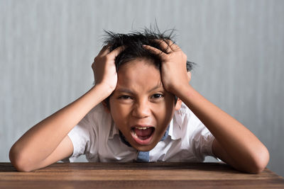 Boy screaming against wall