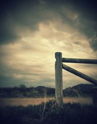 View of field against cloudy sky