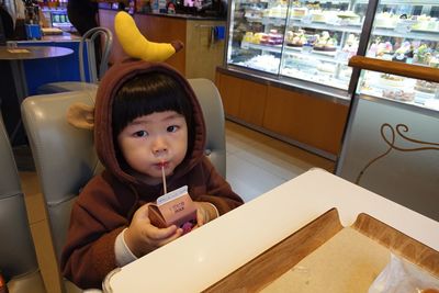 Portrait of cute girl sitting on table