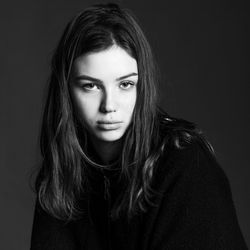 Close-up portrait of a beautiful young woman over black background