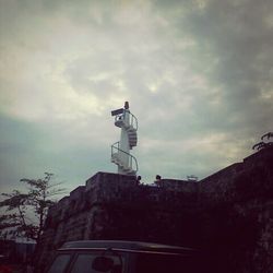 Low angle view of lighthouse against cloudy sky