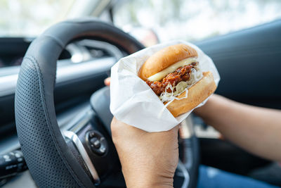 Cropped hand of woman holding burger