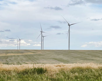 Windmill on field against sky