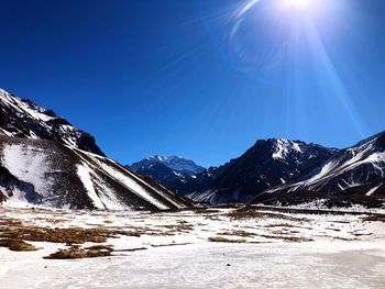 Scenic view of snowcapped mountains against clear blue sky