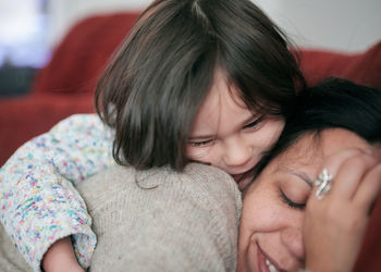 Young girl hugging mom with affection