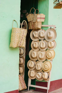 Panama style hats for sale in trinidad, cuba. straw. basket. green walls.