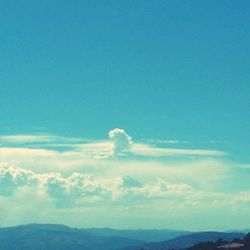Scenic view of mountains against cloudy sky