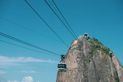 Low angle view of overhead cable car against sky