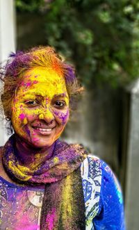 Portrait of smiling woman with powder paint on face during holi