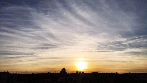 Silhouette cityscape against sky during sunset