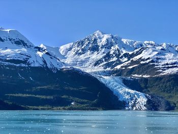 Scenic view of snowcapped mountains against blue sky