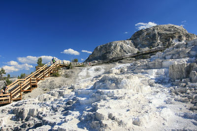 Tourist walking on boardwalk at upper terrace mammoth hot springs in yellowstone national park