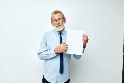Portrait of young man standing against white background