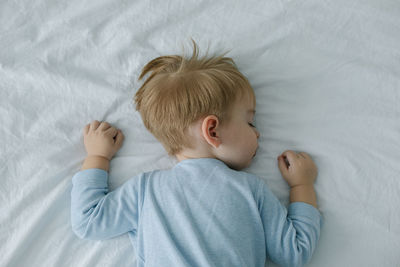 High angle view of baby boy lying on bed at home