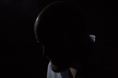 Side view of man against black background