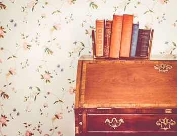 Books on piano against patterned wall