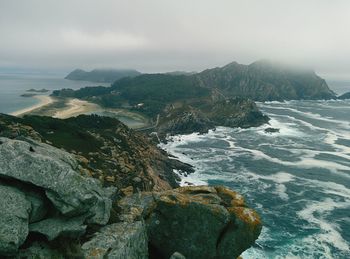 Scenic view of sea and mountains against sky