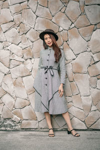 Full length portrait of young woman standing outdoors