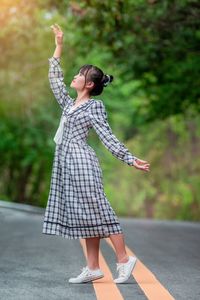 Side view of woman standing on road