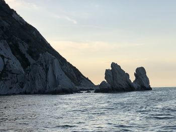 Scenic view of sea and mountains against sky