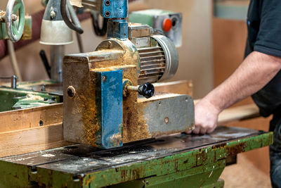 Midsection of man working on machine