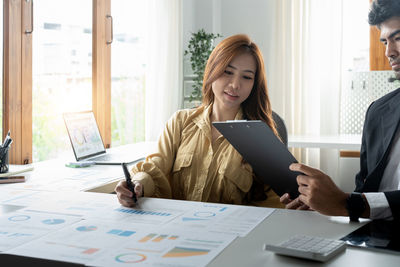 Side view of business colleagues working at office