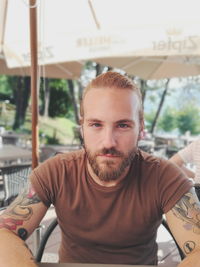 Portrait of bearded man sitting at outdoor cafe