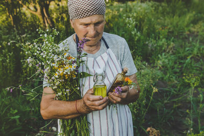 Portrait of young man holding plant