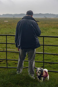 Back view of a man accompanied by his dog