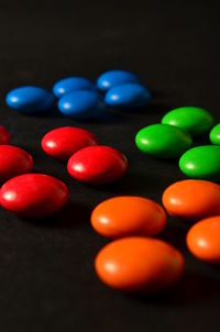 Close-up of multi colored pencils on table against black background