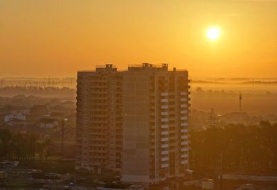 Buildings in city against sky during sunset