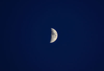 Low angle view of moon against clear blue sky