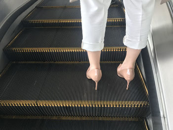 Low section of people on escalator