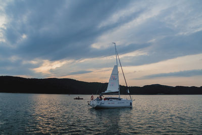 Sailboat in sea against sky during sunset