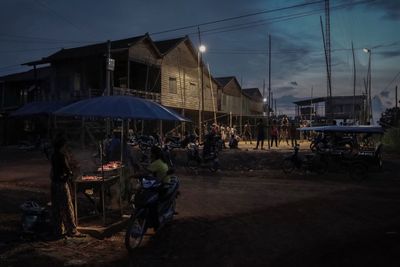 People at street market in city against sky