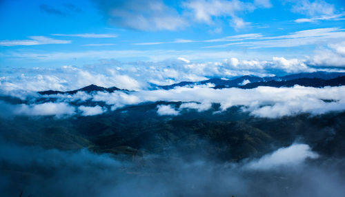 Scenic view of clouds covering mountains against sky