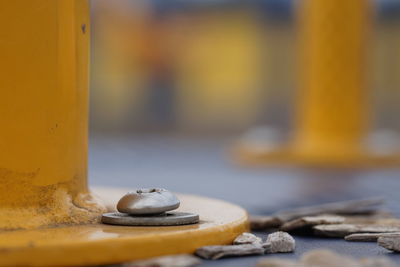 Close-up of bolt on yellow metal pole