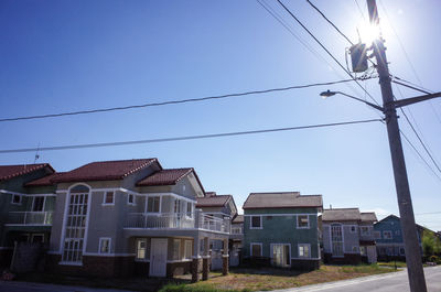 Low angle view of electricity pylon against blue sky