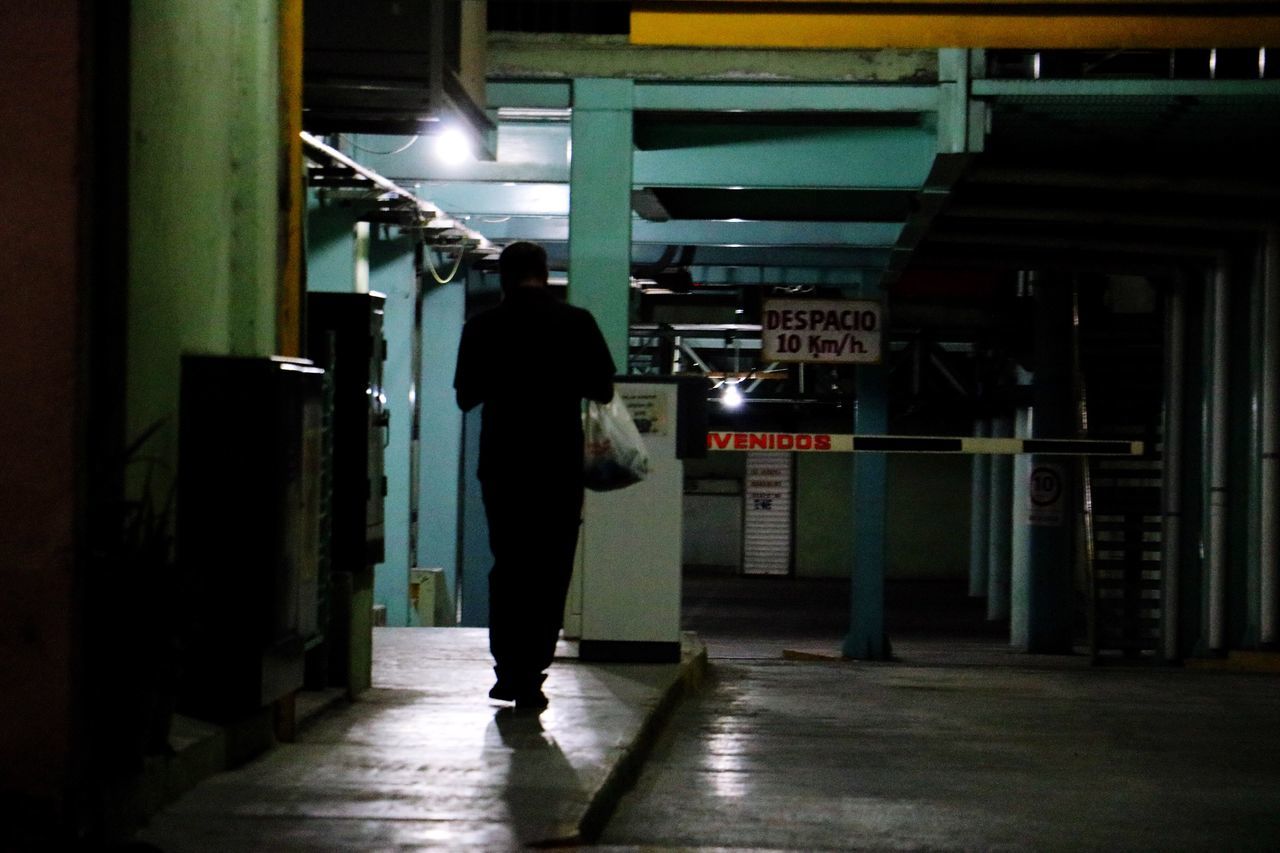 illuminated, real people, one person, indoors, full length, built structure, men, standing, architecture, walking, rear view, night, underground, lifestyles, subway station, one man only, adult, people