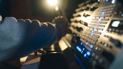 Hands of a man sound engineer are pressing buttons on the console