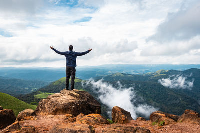 Man in victory pose at mountain top at  morning