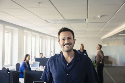 Portrait of team leader standing in office