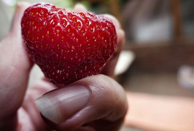 Close-up of hand holding strawberry