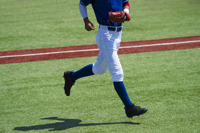 Low section of baseball player running on playing field