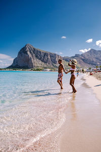 People on beach against sky