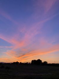 Scenic view of silhouette field against sky during sunset