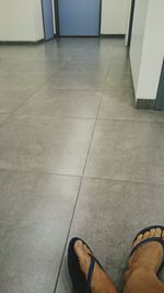 Low section of person standing on tiled floor