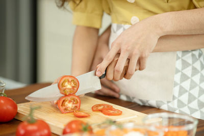 Midsection of woman holding food on table