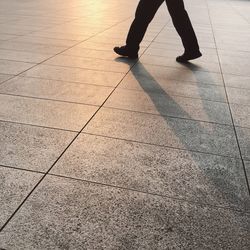 Low section of woman walking on tiled floor