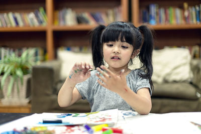 Girl looking at painted hands